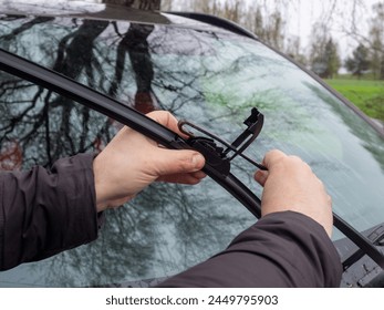 Replacement of car windshield wipers. Change cars wiper blades. Technician Man changing windshield wiper blades on car - Powered by Shutterstock