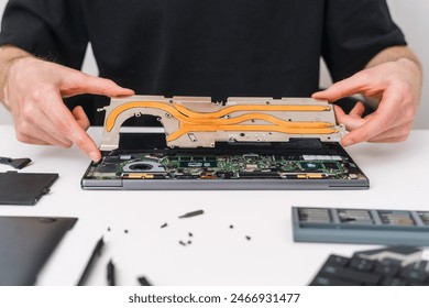 Replacement of elements of the cooling system in the laptop. Man holding motherboard in hands. Warranty service, solution problems, change thermal paste. Man holding component of pc computer in hands