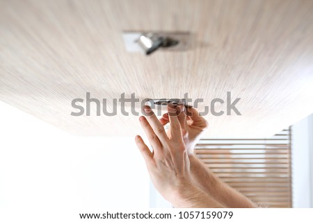 Replacement of a halogen bulb.  The electrician assembles halogen ceiling lights.