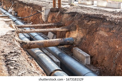 Replacement of heating pipes and modernization of the heating system. Repair of old rusty metal pipes. Construction works on large iron pipes at a depth of excavated trench