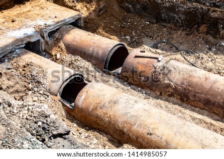 Replacement of heating pipes and modernization of the heating system. Repair of old rusty metal pipes. Construction works on large iron pipes at a depth of excavated trench