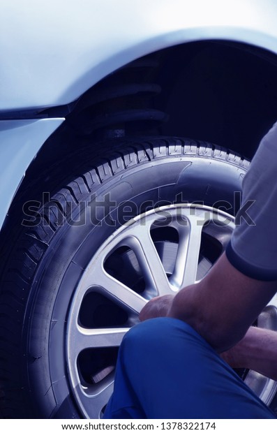 Replacement and maintenance of car tires,\
closeup of a man from the back. Car service.Image\
