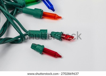Replacing bad bulb in Christmas string lights. Holiday lighting repair, safety and decoration concept.