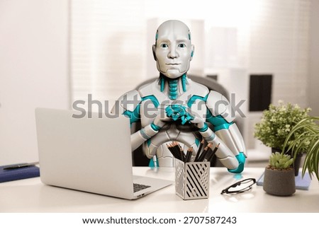 Replacing humans with artificial intelligence. Robot working at table in office. Futuristic technologies