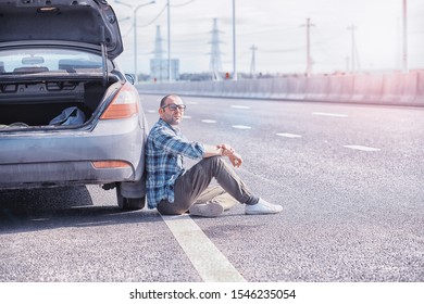 Replacing The Wheel Of A Car On The Road. A Man Doing Tire Work On Sidelines.