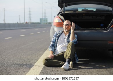 Replacing The Wheel Of A Car On The Road. A Man Doing Tire Work On Sidelines.