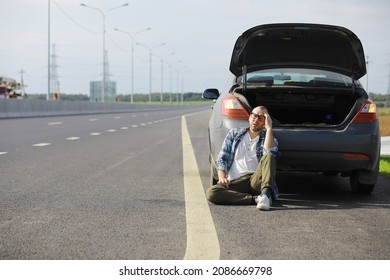 Replacing The Wheel Of A Car On The Road. A Man Doing Tire Work On Sidelines.