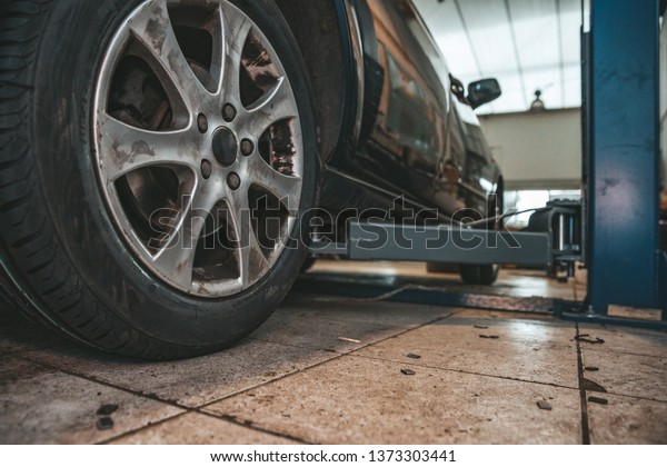 Replacing\
winter tires on summer tires in a professional garage with the help\
of professional tools. car on a hydraulic\
jack