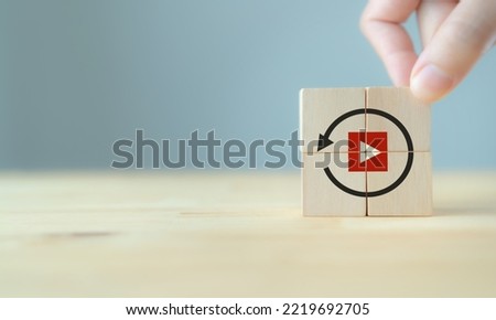 Replay icon on wooden cubes on smart grey background and copy space. Recap business, meeting summary, business review concept. 
