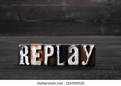 Replay. Text On A Dark Textured Wooden Background.