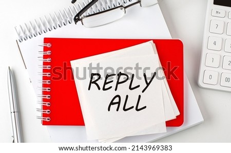 Reply ALL word on a sticker on notepad with pen and calculator