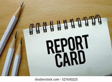Report Card Text Written On A Notebook With Pencils