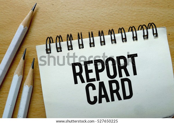 Report Card\
text written on a notebook with\
pencils