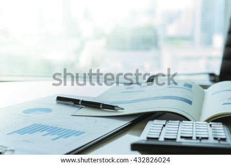 The report summarizes the results of business operations, pen, calculator on desk of investor.
