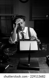 Reporter Working Late At Night And Smoking In His Office, 1950s Film Noir Style.