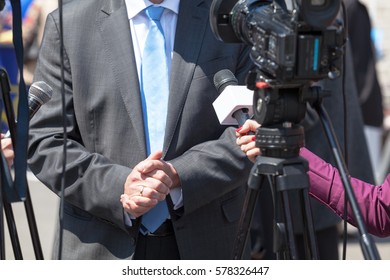 Reporters Holding Microphones Conducting TV Interview. Press Conference.