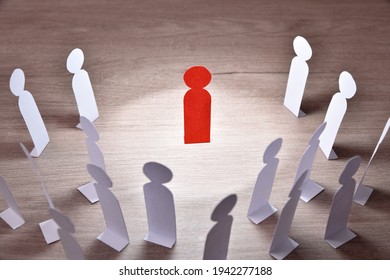 Representation Of Person Preaching In Front Of A Group Of People By Means Of Paper Cutouts In The Shape Of A Person On Wooden Table Elevated View