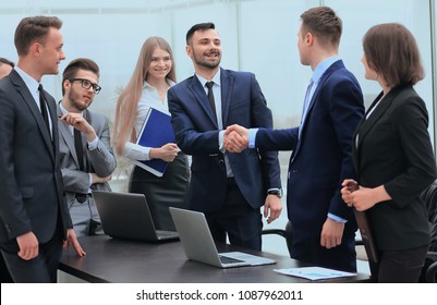 representatives of the two business teams greet each other
