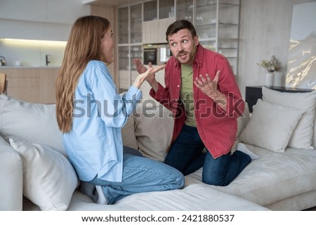 Reproachful angry excited husband blaming wife of money waste, cheating, being bad housewife, shouting while defensive woman brings explanations, arguments in quarrel. Relationship crisis in family Stock photo © 