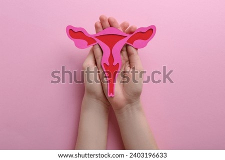 Reproductive medicine. Woman holding paper uterus on pink background, top view Stock photo © 