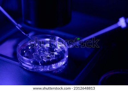 Reproductology laboratory worker micromanipulating with cells in clinic