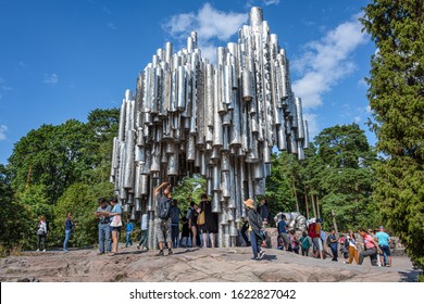 Republic of Finland, Helsinki: Famous Jean Sibelius Monument near the city center of the Finnish capital with people, men, women, children, green trees, public park, blue sky - composer. Jul 29, 2019