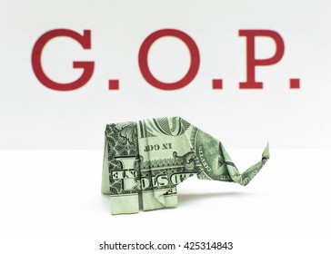 Republican Money - Origami Elephant Made From A Dollar Bill In Front Of The Republican Party's Moniker G.O.P. (Grand Old Party). Using A Faded Color Look.