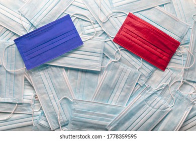 Republican Red And Democrat Blue Medical Face Masks Resting On A Pile Of Other Face Masks.