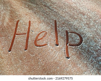 A Request For Help Written On A Dusty Table