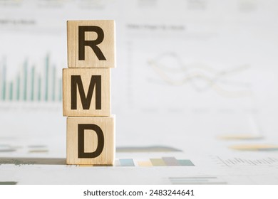 Required Minimum Distribution RMD Concept Represented by Wooden Blocks on Financial Document Background