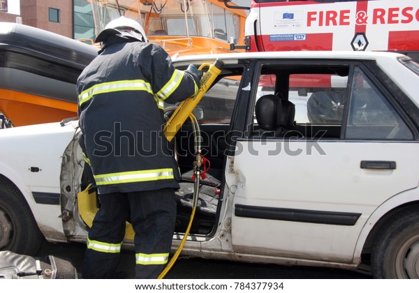 Rescue firefighter in action for saving people from a\
car crash in front of other people in Sofia, Bulgaria - Sep,11,\
2007. 