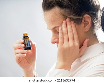 Rescue from headaches with DoTerra therapeutic peppermint essential oil. Alternative methods to improve health. The girl smears whiskey to concentrate. Belarus, Minsk, 2022