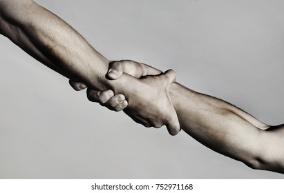 Rescue, helping gesture or hands. Strong hold. Two hands, helping hand of a friend. Handshake, arms, friendship. Friendly handshake, friends greeting, teamwork, friendship. Close-up. Black and white