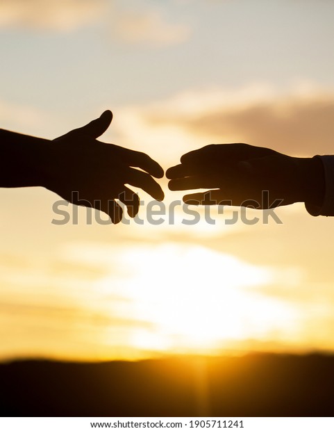 Rescue,\
helping gesture or hands. Two hands silhouette on sky background,\
connection or help concept. Outstretched hands, salvation, help\
silhouette, concept help. Giving a helping\
hand.