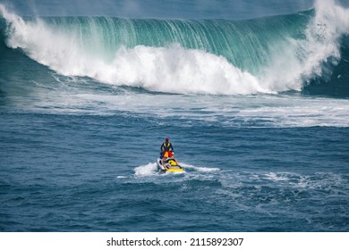 Rescue lifeguard in the ocean in front of a big wave searching for surfers - Powered by Shutterstock