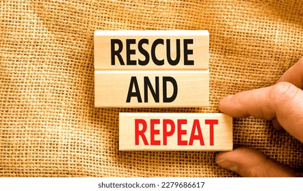 Rescue and repeat symbol. Concept words Rescue and repeat on wooden block on a beautiful canvas table canvas background. Businessman hand. Business rescue and repeat concept. Copy space.