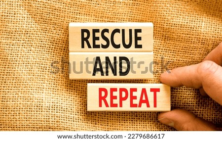 Rescue and repeat symbol. Concept words Rescue and repeat on wooden block on a beautiful canvas table canvas background. Businessman hand. Business rescue and repeat concept. Copy space.