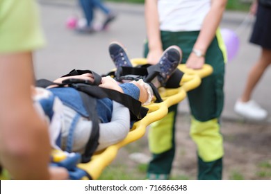 The Rescue Service Evacuates The Injured Child On Stretchers