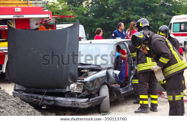 Rescue simulation of\
accident. Val Della Torre, Italy - September, 28 2014: Simulation\
of road accidents, joint intervention between firefighters and\
rescuers.   
