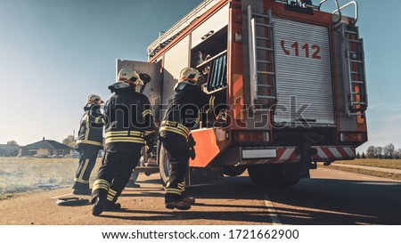 Rescue Team of Firefighters Arrive on the Car Crash Traffic Accident Scene on their Fire Engine. Firemen Grab their Tools, Equipment and, Gear from Fire Truck, Rush to Help Injured, Trapped People