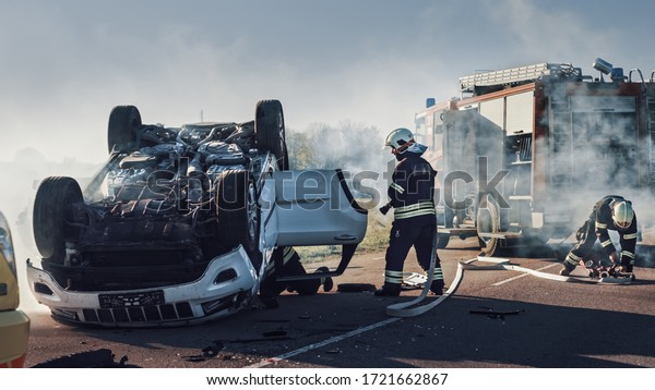 Rescue Team of\
Firefighters Arrive on the Car Crash Traffic Accident Scene on\
their Fire Engine. Firemen Grab their Equipment, Prepare Fire Hoses\
and Gear from Fire\
Truck.