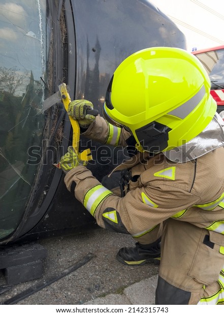The rescue team of firefighters at the scene of the\
traffic accident of the car accident. Firefighters grab their\
tools, gear, and equipment and rush to help injured and trapped\
people. cutting glass