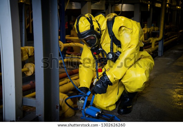 Rescuers in a radiation\
protection suit.
