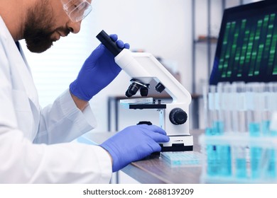 Research in genetics. Scientist working with microscope at table in laboratory, closeup