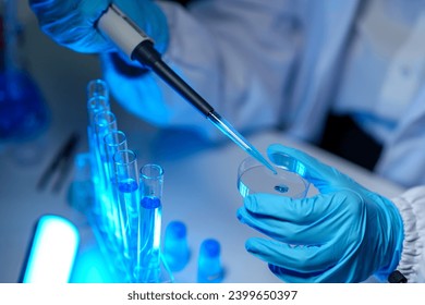 research laboratory. Female scientist uses micro pipette to release chemical liquid into test tube petri dish for test analysis for medicine. Concept of scientific research and development in biology - Powered by Shutterstock