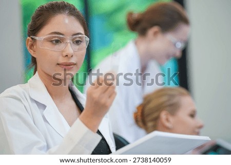 Research team collaborating on microscope analysis. Medical pathology team diagnosing disease via digital microscope. Doctors collaborating on tissue biopsy analysis in bright hospital laboratory.