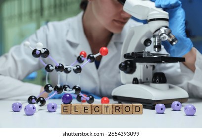 A researcher examines samples through a microscope in a laboratory setting, showcasing molecular models.