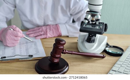 Researcher takes notes while examining samples under a microscope in a laboratory setting