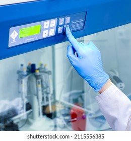 A Researcher Is Turning On The Safety Laminar Flow Cabinet In A Cell Culture Laboratory In Order To Initiate A Work With Deadly Human Virus. The Cabinet Provides Sterile Environment For Such Work.