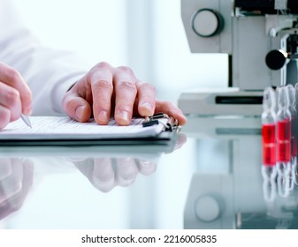 Researcher Writes Down The Results Of Research In A Laboratory Journal.